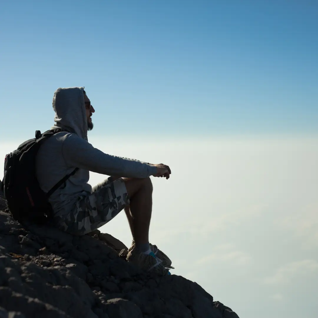 mann sitzt auf einem berg